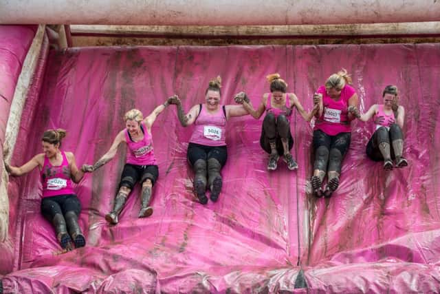 Women pictured as they take on an inflatable slide at a previous Pretty Muddy.