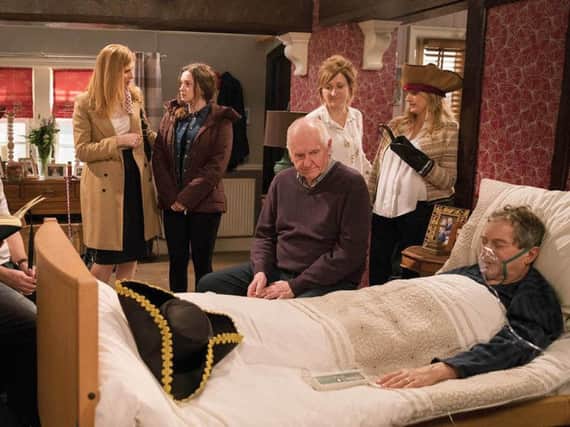 Ashley Thomas with his family and friends at his bedside ahead of his death in an emotional episode of the soap on Friday. Picture: PA/ITV.