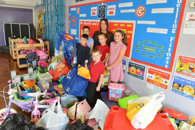 Teacher Rebecca Baxter with pupils and items donated in the aftermath of the fire.