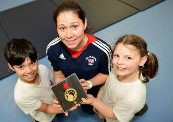 Louise Renicks shows her Commonwealth Judo gold medal to Eskdale Academy pupils Jayden Hague and Faith Holland. Picture by FRANK REID