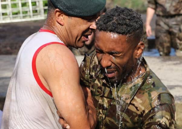 Jermain Defoe emerges from the 'sheep dip' on the Royal Marines course.