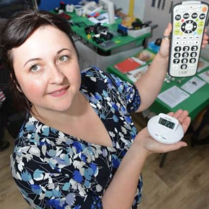 Fran Smith of In Good Hands, deaf blind support project holding a vibrating pillow alarm and a large button TV remote at the Hartlepool Carers. Picture by FRANK REID