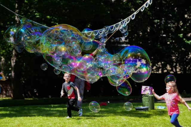 Youngsters have fun with bubbles at the Great Get Together community picnic.