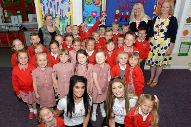 Singers Georgia Fletcher (left) and Olivia Cranford with staff and pupils at Blackhall Primary School Picture by FRANK REID