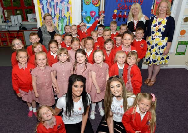 Singers Georgia Fletcher (left) and Olivia Cranford with staff and pupils at Blackhall Primary School Picture by FRANK REID