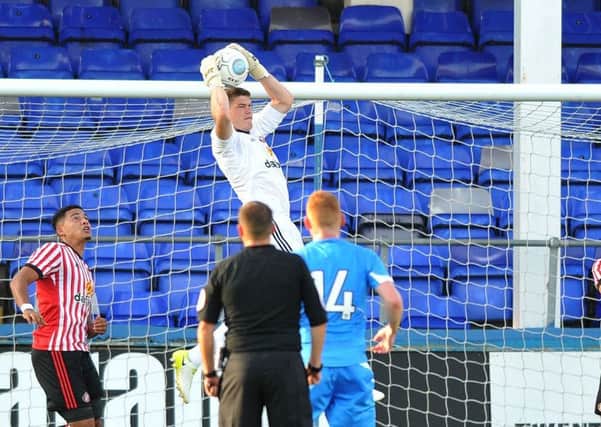 Sunderland goalkeeper Max Stryjek rises high to claim the ball comfortably.