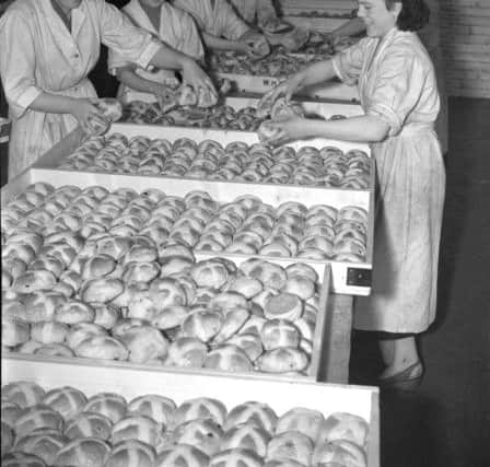 A busy scene at the Hartlepool Co-op bakery where workers are filling trays with buns.