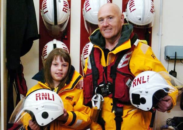 Hartlepool RNLI station mechanic Garry Waugh with eight-year-old Ciar Astley during the Brownies' visit to the Ferry Road boathouse. Pic: RNLI/Tom Collins.