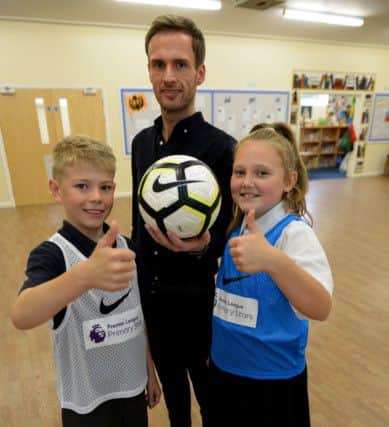 Greatham Primary school acting headteacher Michael Piper with school football team members Turner Kinnersley and Tilly Bailey Picture by FRANK REID