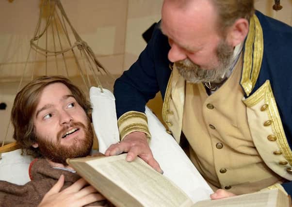 National Museum of the Royal Navy staff member Stuart Burke reads a scary night time story to Jonathan Clough. Picture by FRANK REID