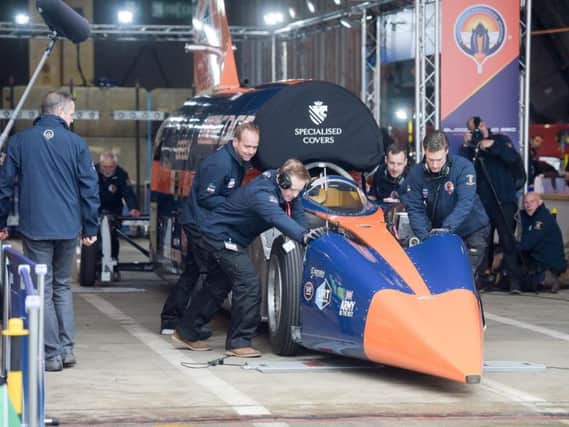 Pilot Andy Green steers as Bloodhound SSC is towed out of the hangar by technicians at Newquay airport, Cornwall. Pic: PA.