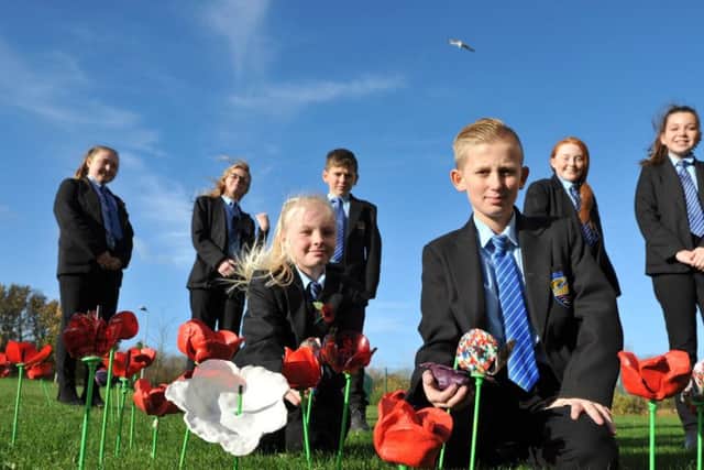 Dene Community School pupils Katelyn Daniels and Christopher Pearson add their poppy's to the school Remembrance Garden.