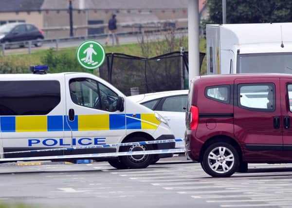 A police van and security van in a taped off area in Asda car park Marina Way.