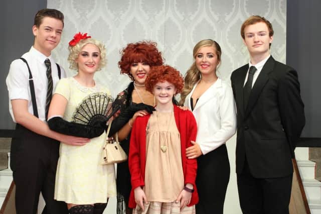 Students taking part in show Annie, cast characters Rooster, Lily, Miss Hannigan, Annie, Grace Farell, Oliver Warbucks.