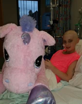 In the pink - Elly Mae Waugh sharing her hospital bed with a new toy.