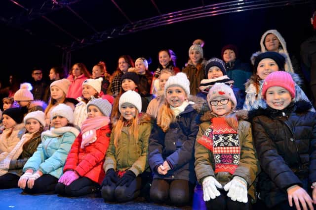 Singers from Miss Toni's Academy of Singing & Performing Arts waiting to sing on stage before the Christmas lights switch