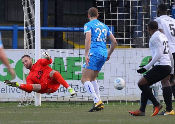 Scott Loach is beaten at his near post for Dover's opener.