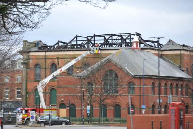 Firefighters carry out a check of the building's roof today.