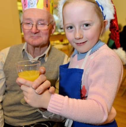 Thornley Primary school pupil Alisha Lonsdale, seven, serves a glass of orange juice to 75-year-old Gary Piercy.