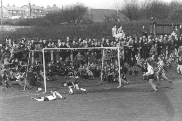 A huge crowd for the semi-final replay at Easington CWs ground where an Essex player has just scored an own goal.