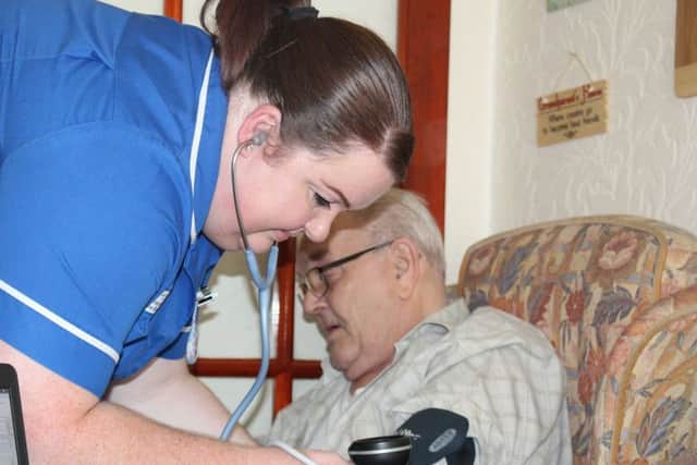 Louise helps one of her patient Fred, 79.