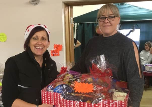 Local Slimming World consultant Ali Stokes presents Lindsay Twitty with a hamper prize at the fundraising event.