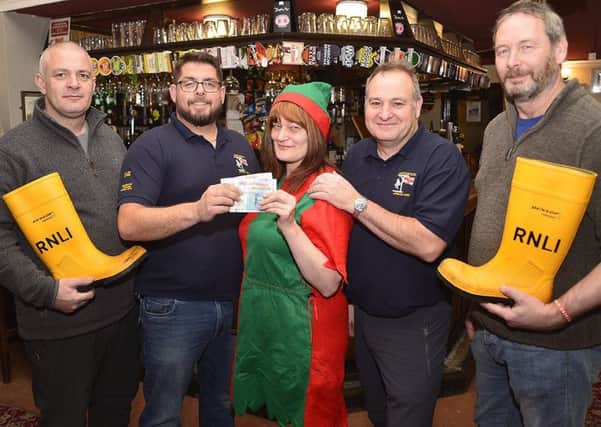 Fishermans Arms landlady Hazle Whitelock presents the cash donation to Andy Johnson and fellow cyclists Wayne Platt(left) Darren Killick and Steve Bell(right). Picture by Tom Collins.