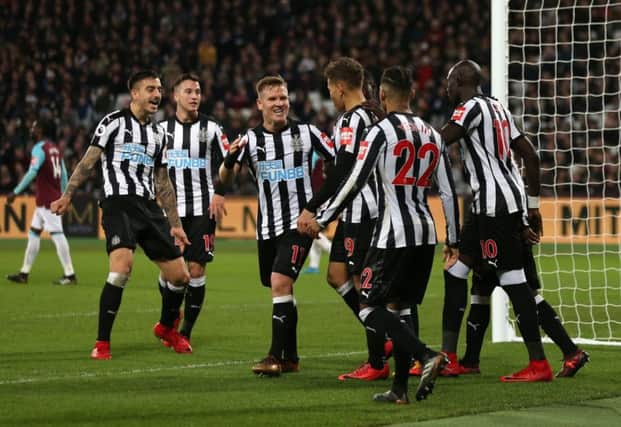 Newcastle players celebrate their third goal at West Ham.