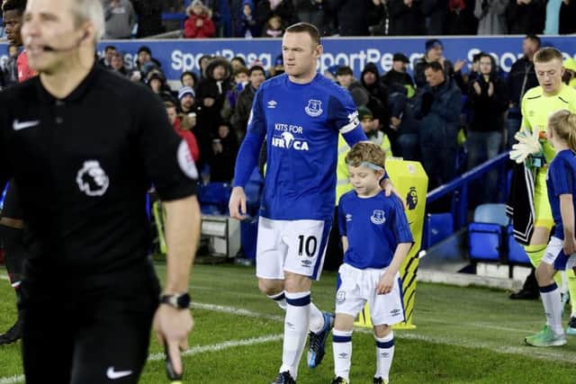 Alex walking onto the pitch with his hero Wayne Rooney.