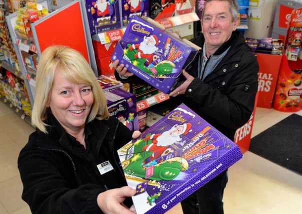 Janette Gillies team manager at McColls, Headland presents Kevin Jones carnival committee member with Christmas selection boxes. Picture by FRANK REID
