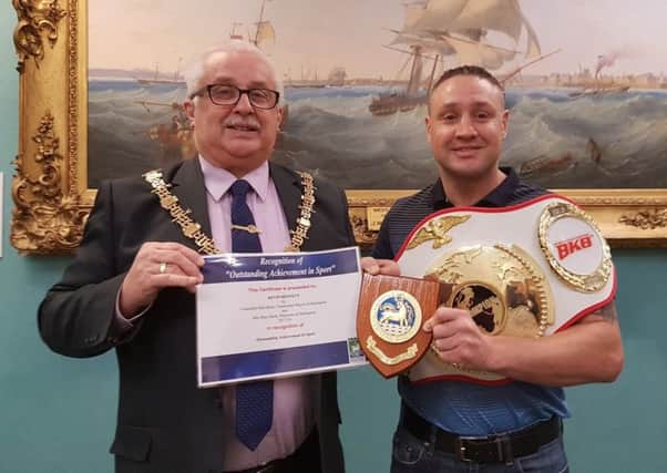 The Mayor of Hartlepool, Councillor Paul Beck, presents the plaque and certificate to Kevin Bennett, who is wearing one of his two bare knuckle boxing world title belts.