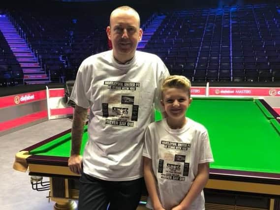 Snooker player Mark Williams and son Kian wear their T-shirts at Alexandra Palace