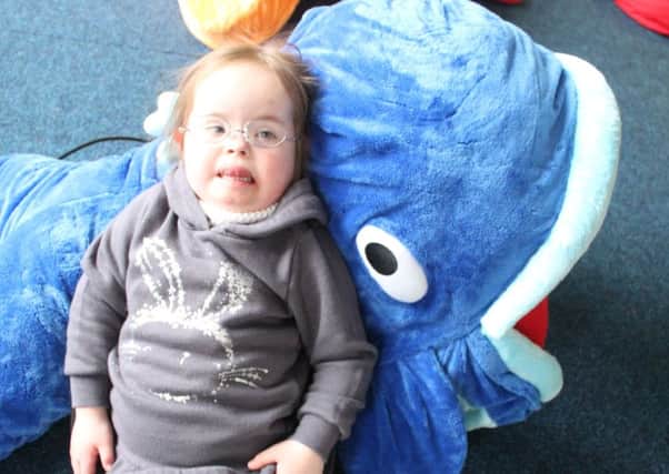 One of Families First's young clients enjoys using a whale soft toy.