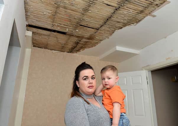 Lauren Pickering with two-year-old son George Sargent under the damaged ceiling of her Wolviston Road home. Picture by FRANK REID