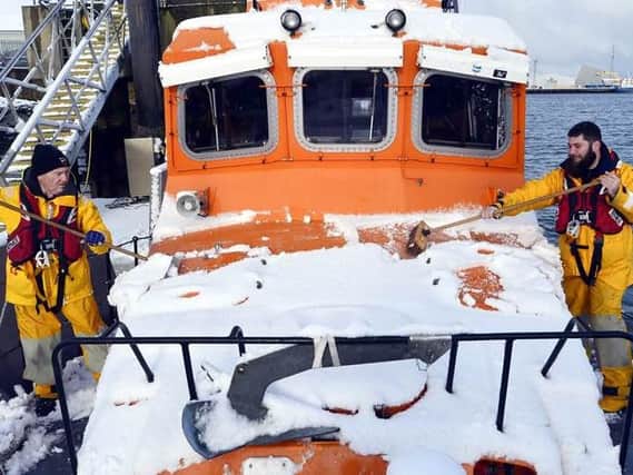 Hartlepool RNLI station mechanic and second coxswain Garry Waugh(left) and volunteer crew member Craig Pinder clearing snow from the all weather lifeboat at Hartlepool this morning after a heavy overnight fall of snow. Pic by Tom Collins