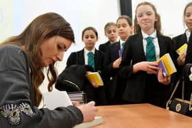 Author Katy Birchall signing copies of her books for pupils at Manor Community College. Picture by FRANK REID