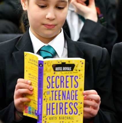 Manor Community College pupil Sophia Fenwick reading her signed copy of Secrets of a Teenage Heiress by visiting Author Katy Birchall. Picture by FRANK REID