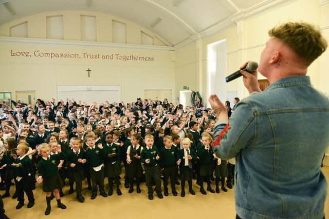 Michael Rice performing to current pupils in the main hall of his former school St Aidan's Primary. Picture by Frank Reid