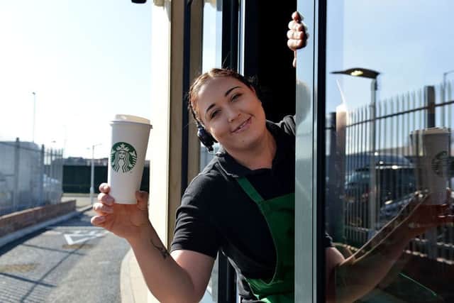 Rachael Dickinson serving the first drive thru customer during the opening of Starbucks. Picture by Frank Reid