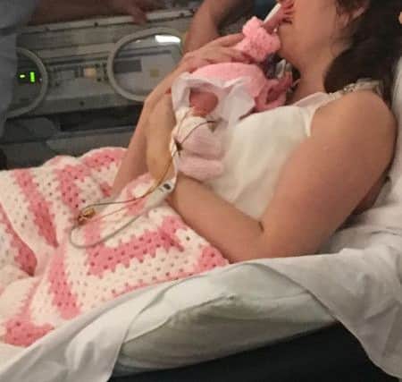 Tracey Keers on her wedding day cradling her premature baby, Kyla.