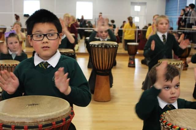 Children have a go at playing the drums.