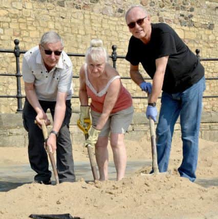 (Left to right) James Ingram, Sandra Hunter and Brian Hogg getting stuck in to the task of clearing sand away from the Headland paddling pool. Picture by Frank Reid