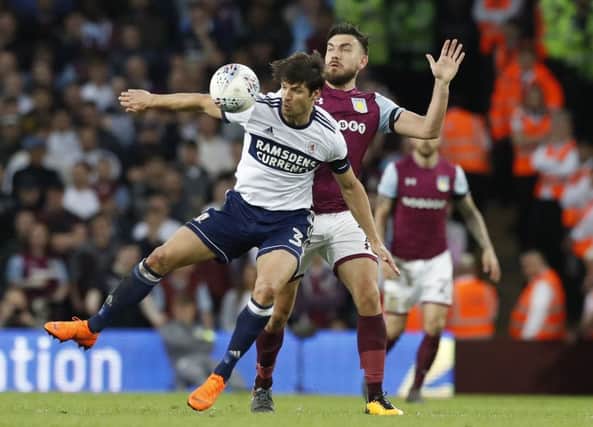 Middlesbroughs George Friend takes on Aston Villas Robert Snodgrass at Villa Park.