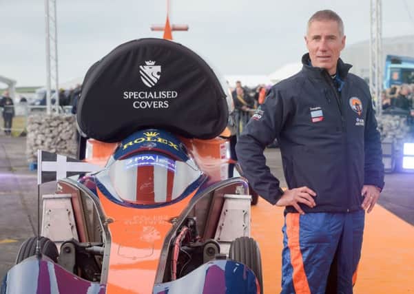 Pilot Andy Green stands beside the Bloodhound 1,000mph supersonic racing car before its first public run at Cornwall Airport, near Newquay. Photo: Ben Birchall/PA Wire