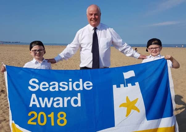Coun Dave Hunter celebrates Seaton Carews Seaside Award with six-year- old twins Billy (left) and Leo Fleming, who were enjoying a trip to the beach.