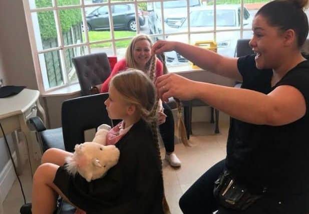 Little Emily Atkinson in the hot seat with her hairdresser.