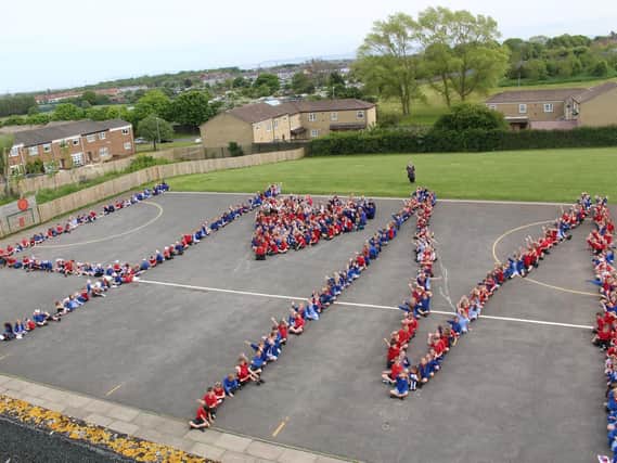 A stunning aerial view of the children of Throston Primary School spelling out Harry and Meghan's initials